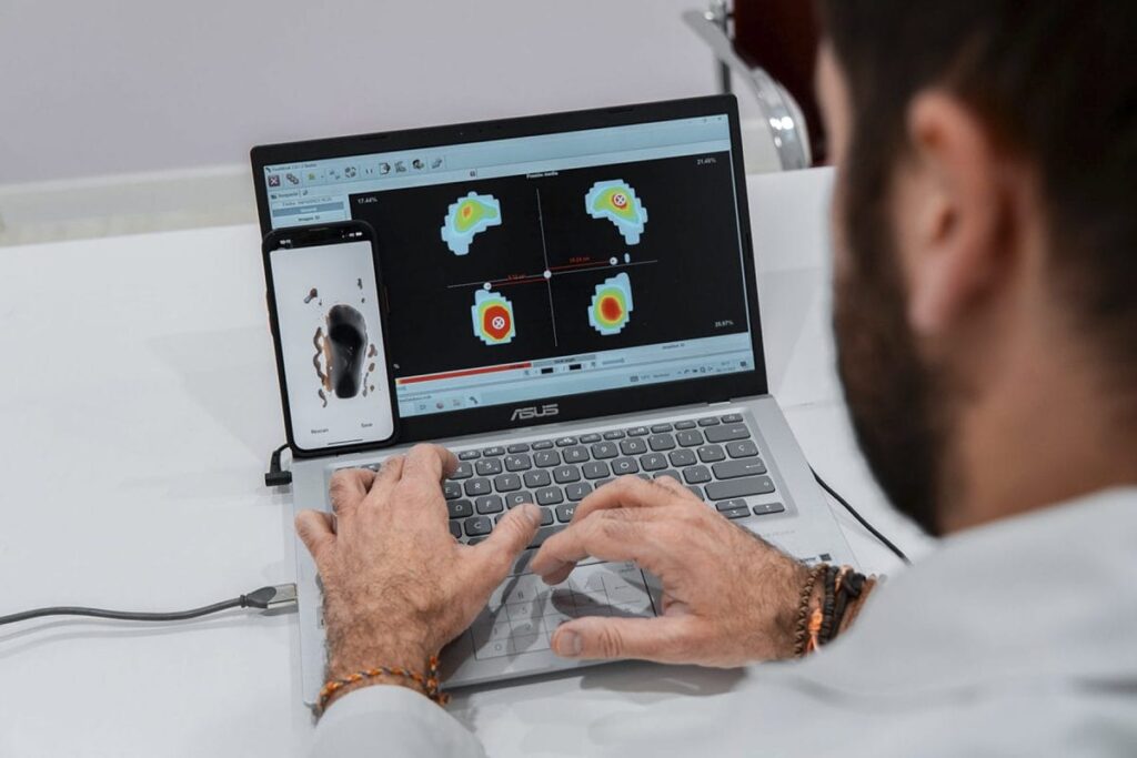 Podólogo mirando un estudio de la pisada en el ordenador