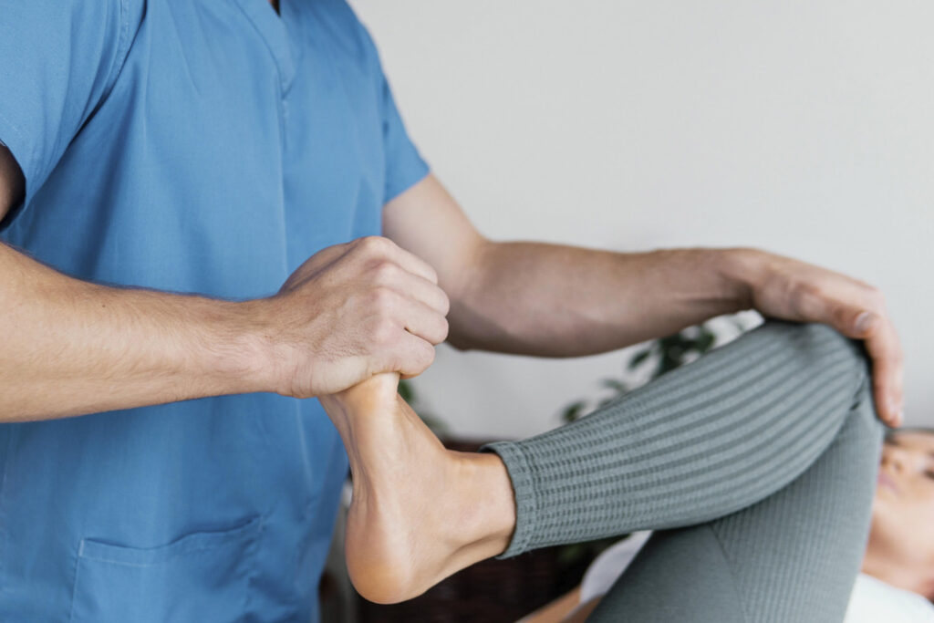 fisioterapeuta realizando un ejercicio de pierna a un paciente